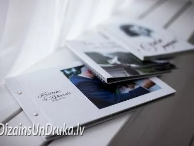 Uz palodzes novietota kāzu fotogrāmata un citi personalizēti albumi