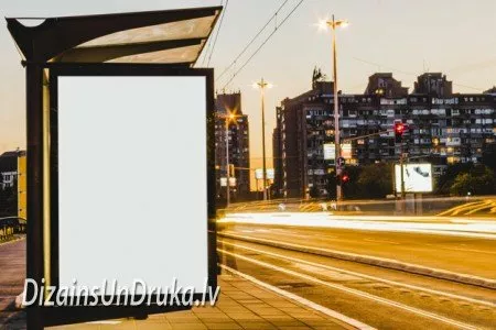 Blank advertising poster at a city bus stop against evening traffic