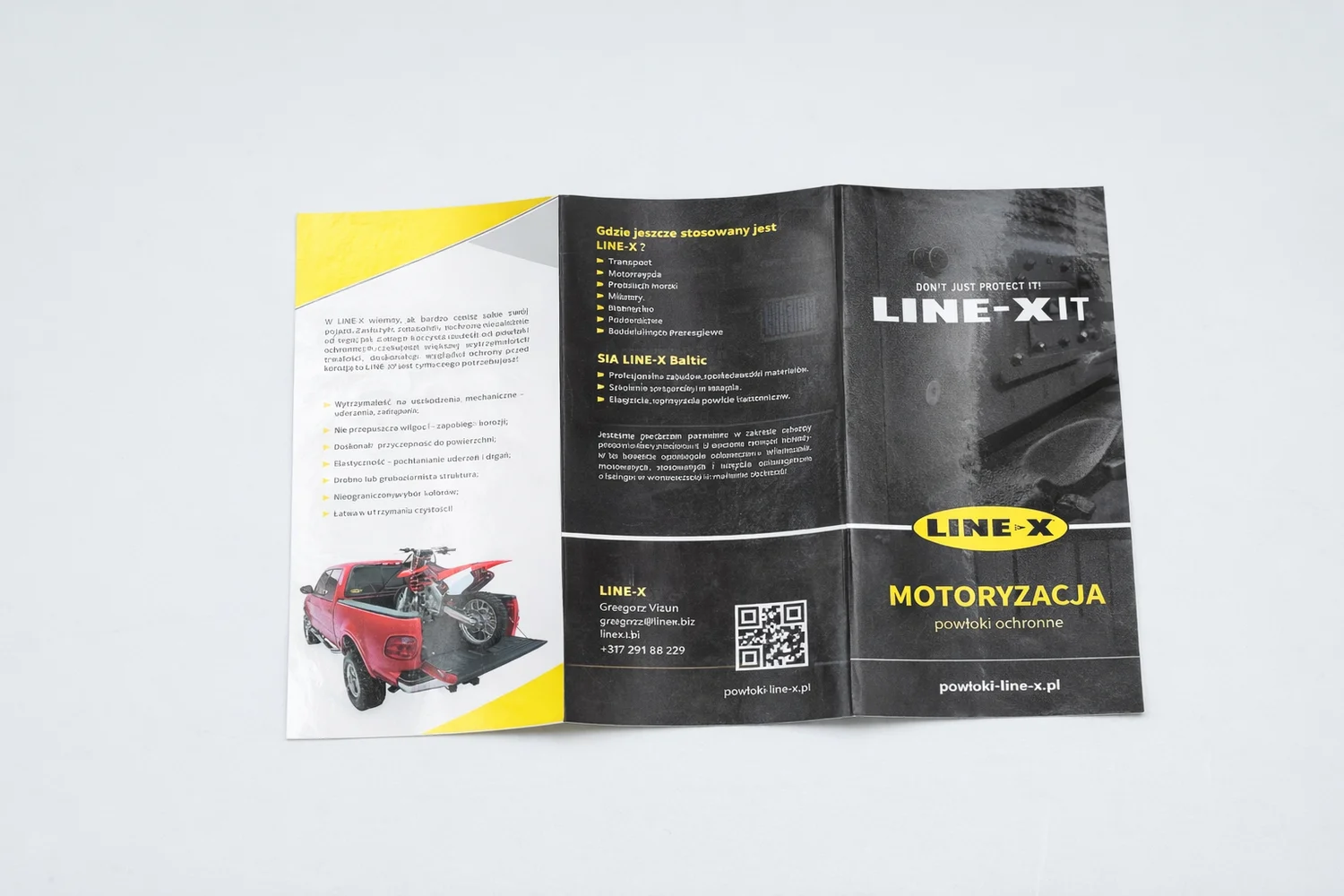 Открытая брошюра LINE-X на сером фоне с изображениями авто и текстом на польском