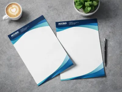 Custom letterhead printing sample with blue design and logo on a gray desk by coffee