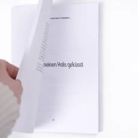 Hand turning a page in a high-quality soft cover book for custom book printing