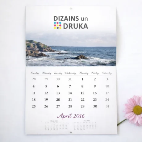 Custom flip wall calendar with a seascape and April month beside a pink flower