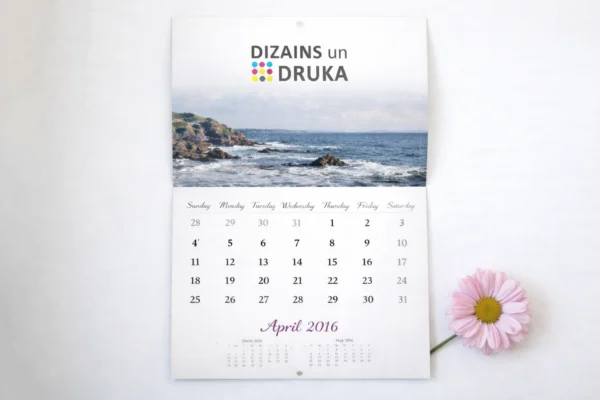 Custom flip wall calendar with a seascape and April month beside a pink flower