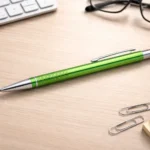 Green engraved metal pen on a desk