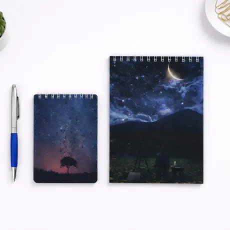 Divi spirāles bloknoti ar nakts debesu dizainu, ilustrējot bloknotu izgatavošanu un druku