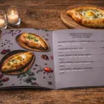 Open A4 booklet for custom menu printing with khachapuri photos and price list on a wooden table