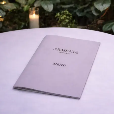 Elegant A4 booklet menu for Armenia restaurant on a white table with a candle in the background