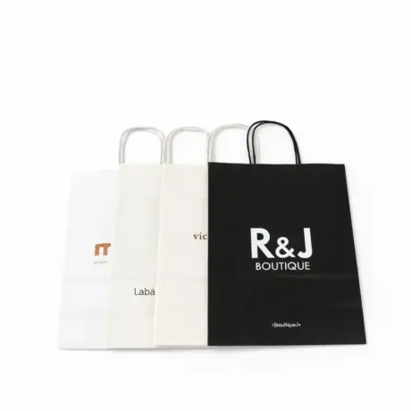 Various custom paper bags with print, including a black R&J Boutique bag