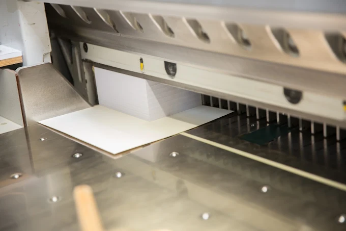 Sheet of paper in a cutting machine with a metal surface and blades