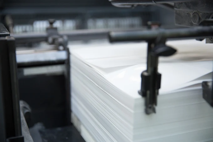 Close-up of a stack of white paper in a printing machine