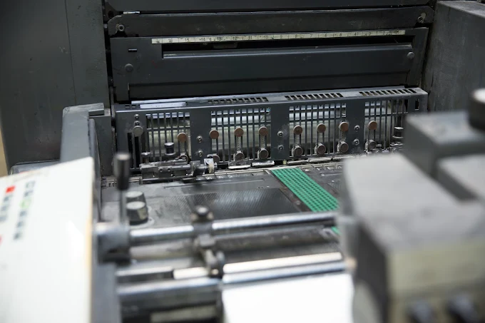 Industrial machine metal mechanism with a grated panel and green strip