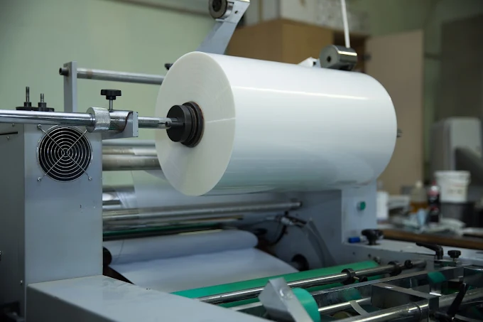 Large roll of white film on industrial machine in a production room