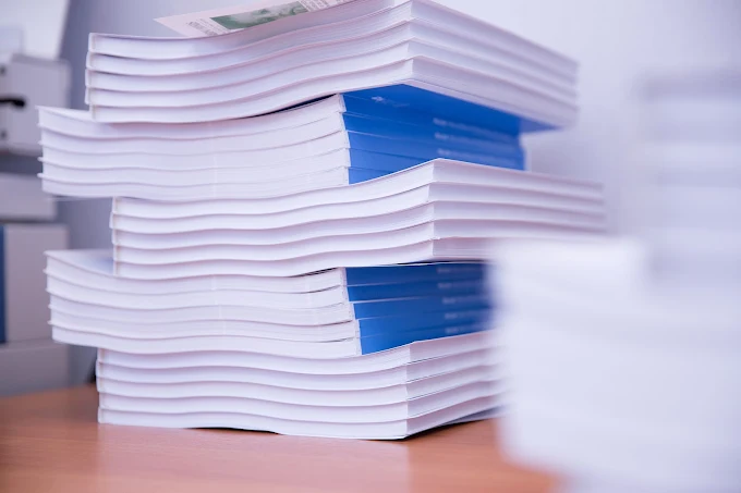 Stacks of white and blue brochures on a table