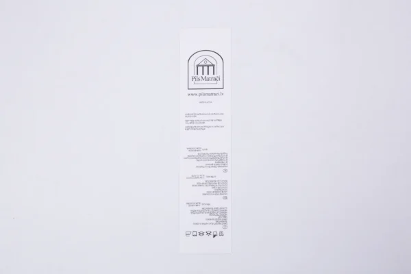 White custom nylon label printing with Pils Matrači logo and care instructions