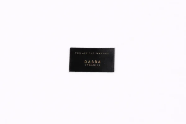 Black custom satin label with gold DABBA ORGANICS print