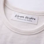 Custom satin label printing on light clothing with black Dream Mishka logo