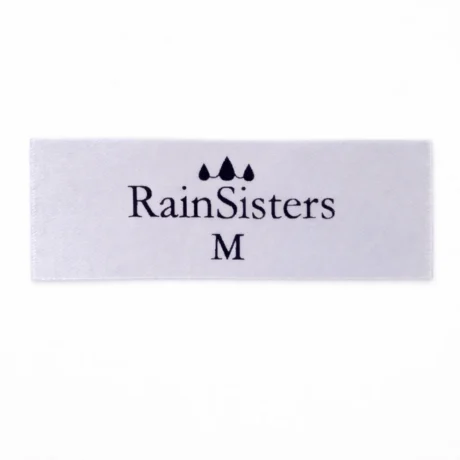 White custom satin label with black print, RainSisters logo and size M